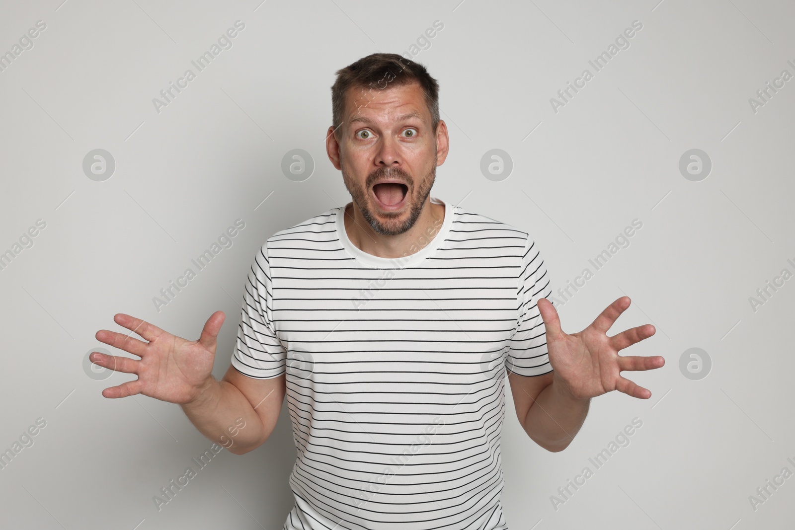 Man suffering from panic attack on light grey background Photo of Man suffering from panic attack on light grey background