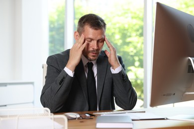Photo of Panic attack. Businessman calming himself down at workplace in office