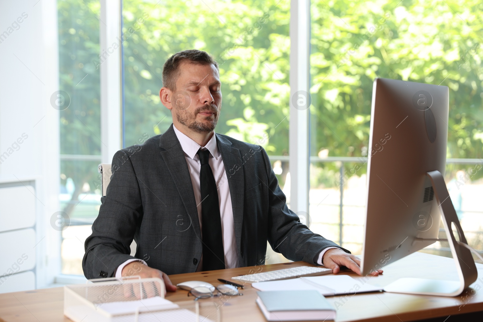 Panic attack. Businessman calming himself down at workplace in office Photo of Panic attack. Businessman calming himself down at workplace in office