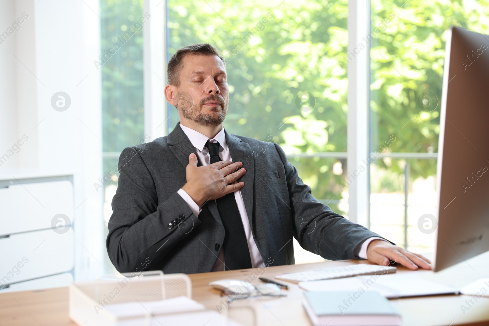 Photo of Panic attack. Businessman breathing to calm down at workplace in office