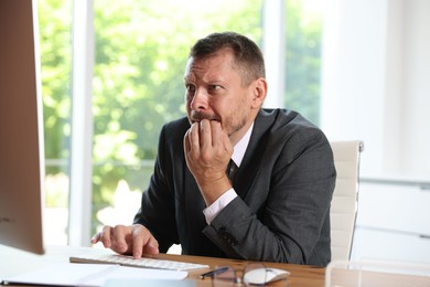 Photo of Businessman suffering from panic attack at workplace in office