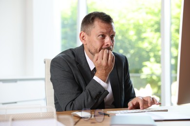 Photo of Businessman suffering from panic attack at workplace in office