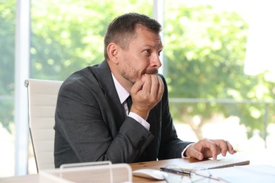 Photo of Businessman suffering from panic attack at workplace in office