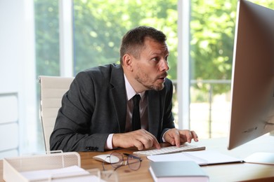 Photo of Businessman suffering from panic attack at workplace in office