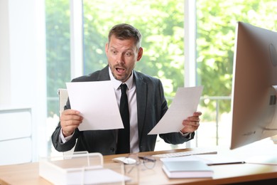 Photo of Businessman suffering from panic attack at workplace in office