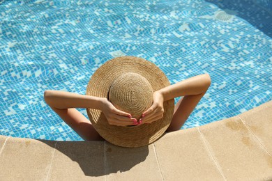 Photo of Girl with straw hat in outdoor swimming pool, above view