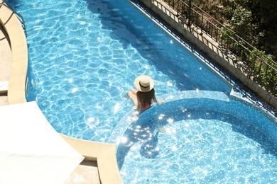 Photo of Beautiful girl with straw hat in outdoor swimming pool, above view