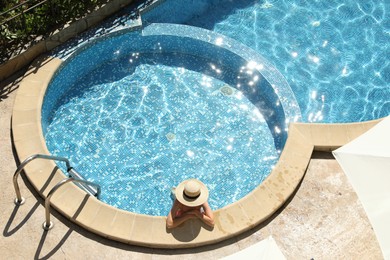 Photo of Beautiful girl with straw hat in outdoor swimming pool, above view