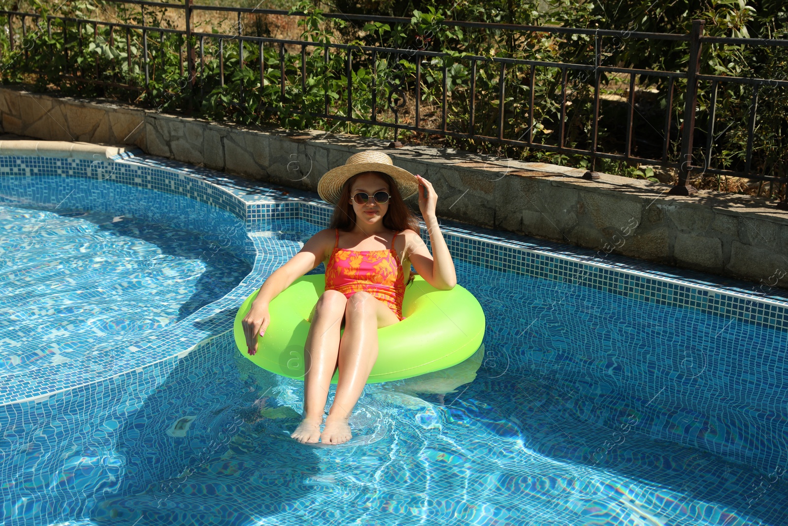 Photo of Beautiful girl on inflatable ring in swimming pool