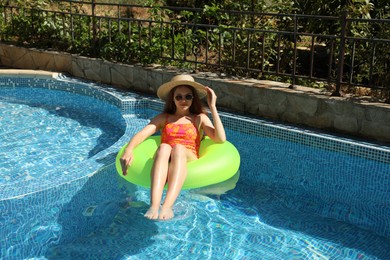Photo of Beautiful girl on inflatable ring in swimming pool