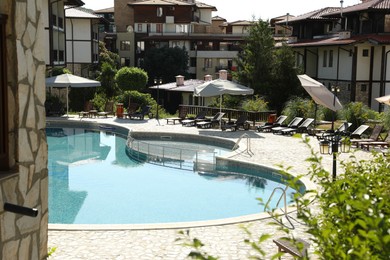 Photo of Outdoor swimming pool and sunbeds near hotel at luxury resort