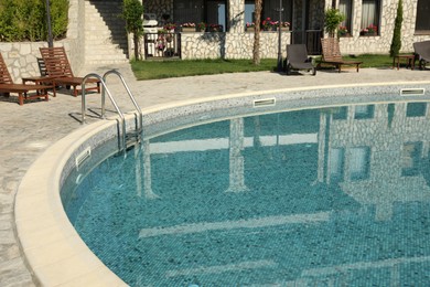 Photo of Outdoor swimming pool and sunbeds near hotel at luxury resort