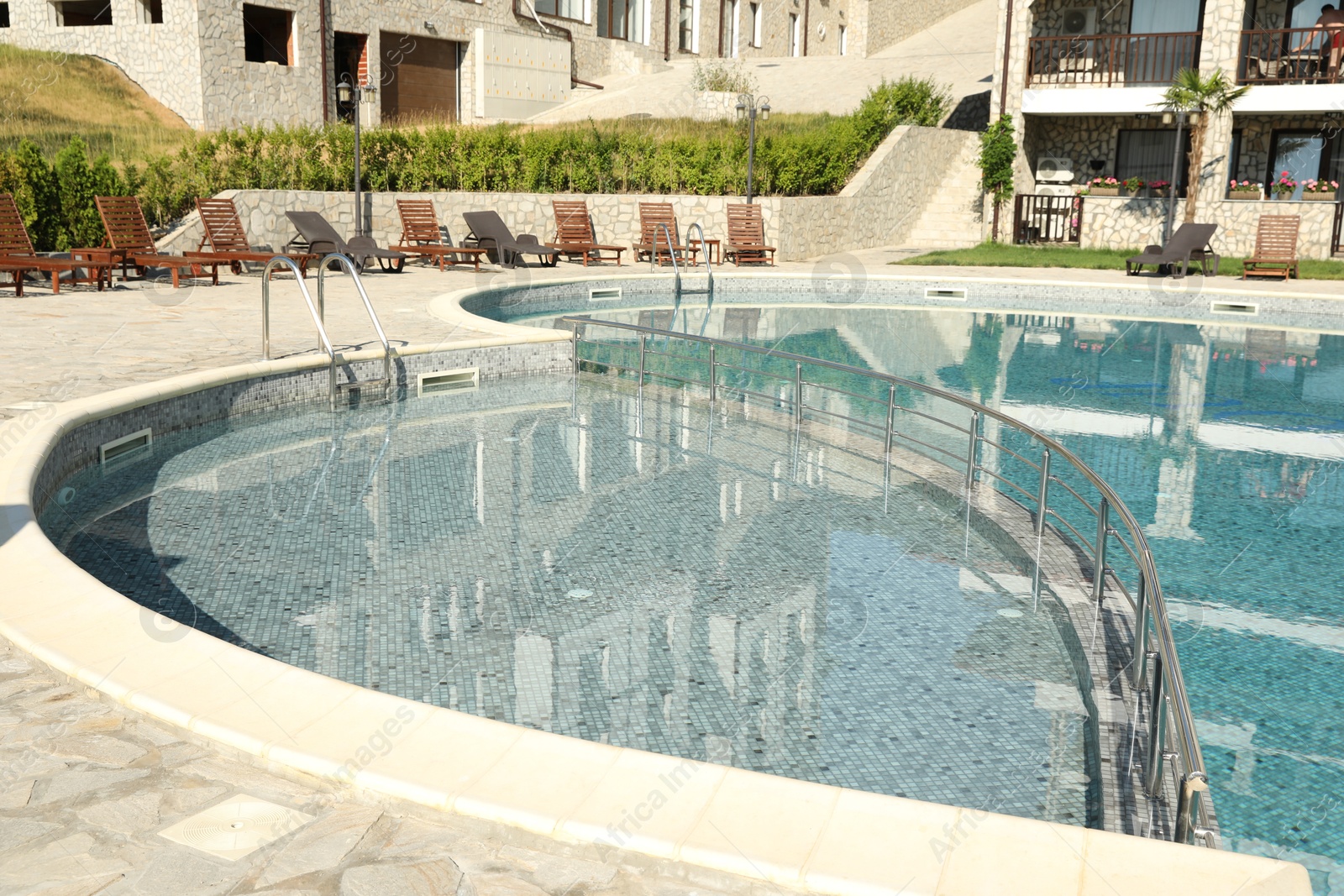 Photo of Outdoor swimming pool and sunbeds near hotel at luxury resort