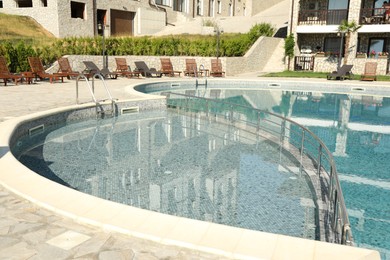 Photo of Outdoor swimming pool and sunbeds near hotel at luxury resort