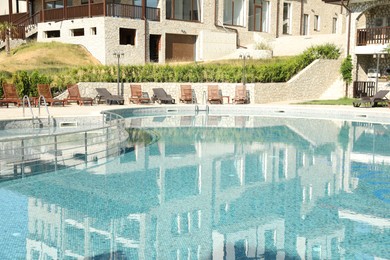 Photo of Outdoor swimming pool and sunbeds near hotel at luxury resort