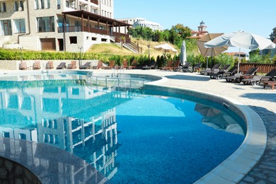 Photo of Outdoor swimming pool and sunbeds near hotel at luxury resort