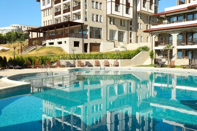 Photo of Outdoor swimming pool and sunbeds near hotel at luxury resort