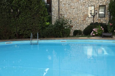 Photo of Outdoor swimming pool and green plants near hotel at luxury resort