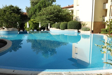 Photo of Outdoor swimming pool and green plants at luxury resort