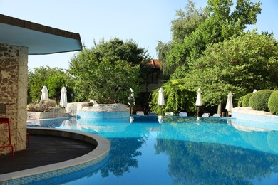 Photo of Outdoor swimming pool and green plants at luxury resort
