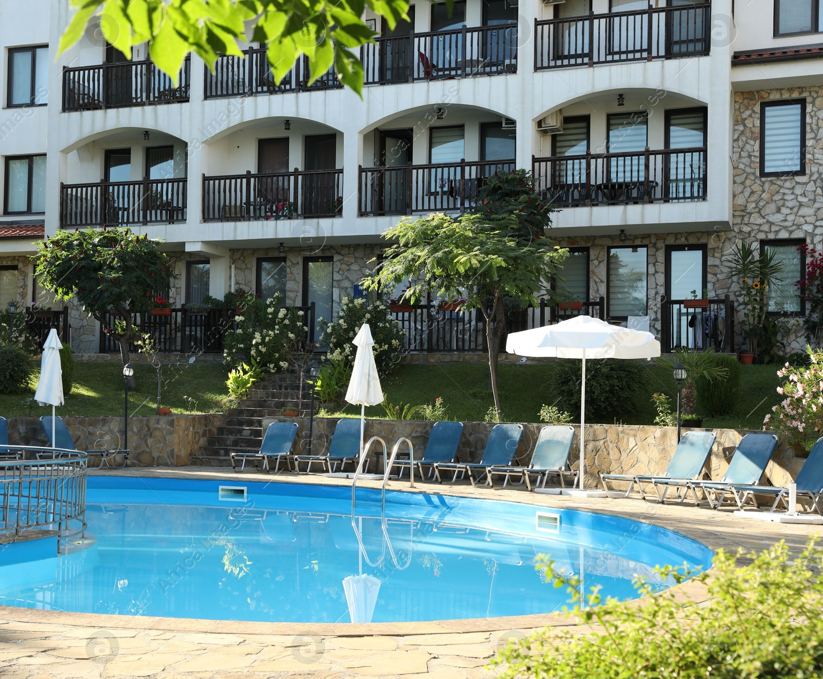 Photo of Outdoor swimming pool and sunbeds near hotel at luxury resort
