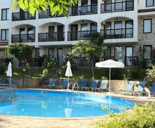 Photo of Outdoor swimming pool and sunbeds near hotel at luxury resort