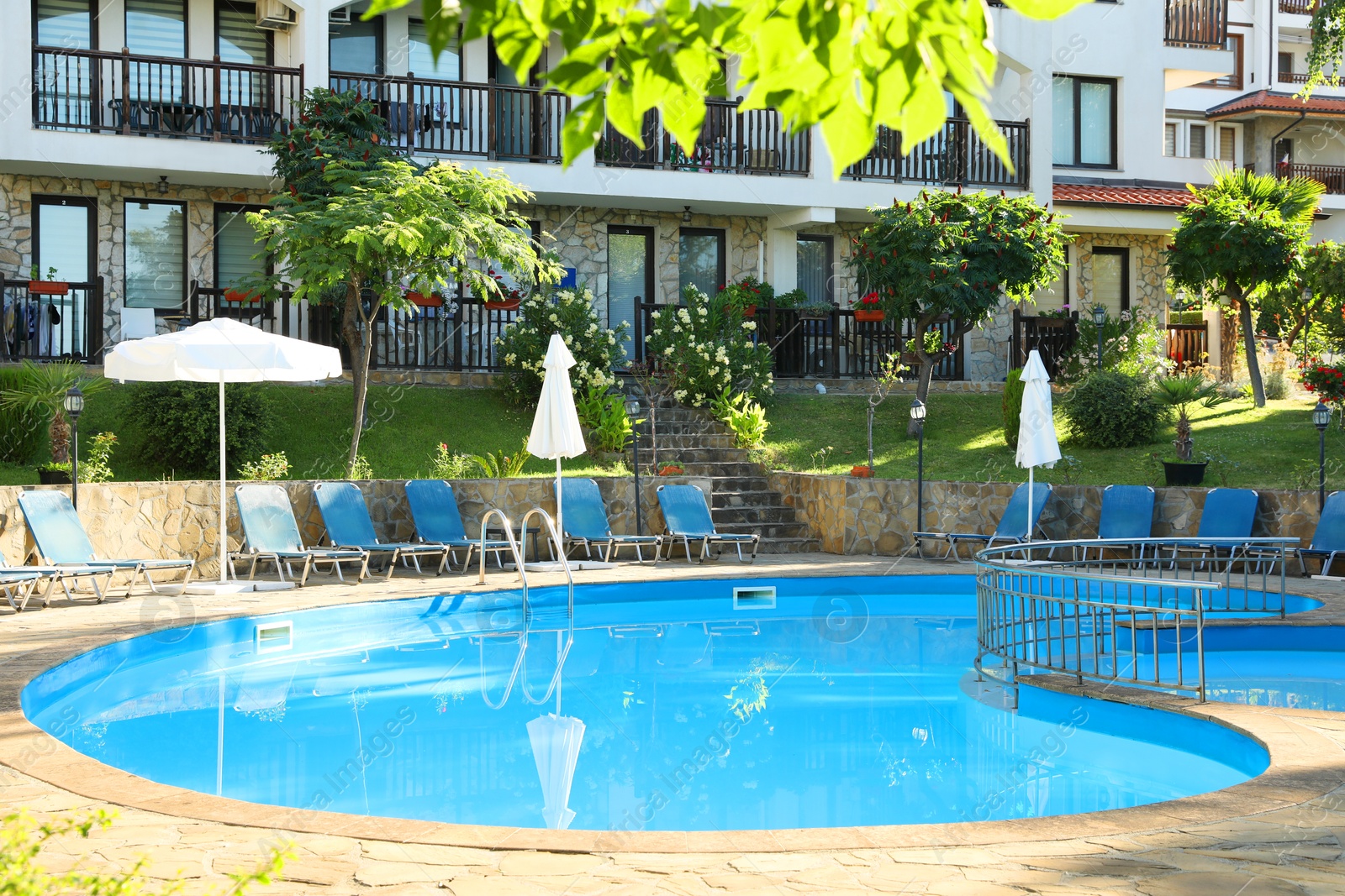 Photo of Outdoor swimming pool and sunbeds near hotel at luxury resort