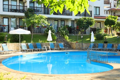 Photo of Outdoor swimming pool and sunbeds near hotel at luxury resort