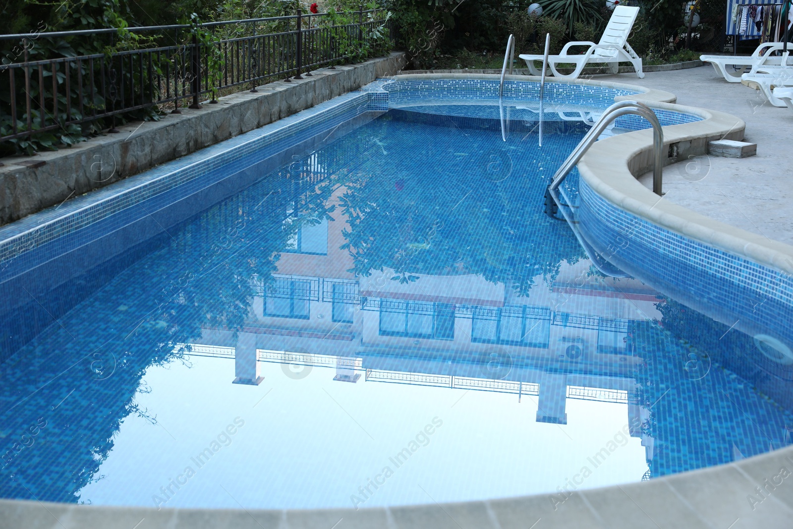 Photo of Outdoor swimming pool and different green plants, closeup