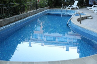 Photo of Outdoor swimming pool and different green plants, closeup