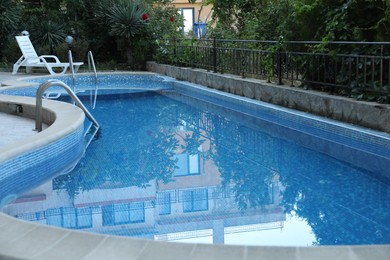 Photo of Outdoor swimming pool and different green plants, closeup