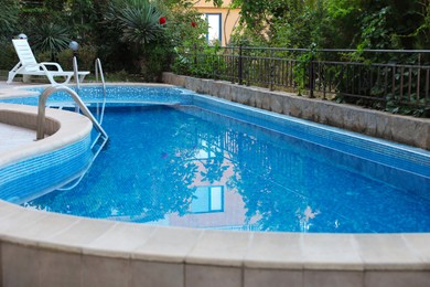 Photo of Outdoor swimming pool and different green plants, closeup