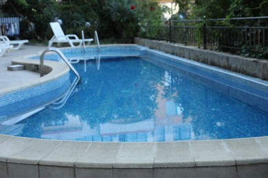 Photo of Outdoor swimming pool and different green plants, closeup