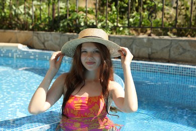 Photo of Girl with straw hat in swimming pool outdoors