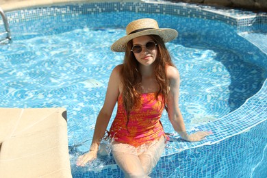 Photo of Girl with straw hat in swimming pool outdoors