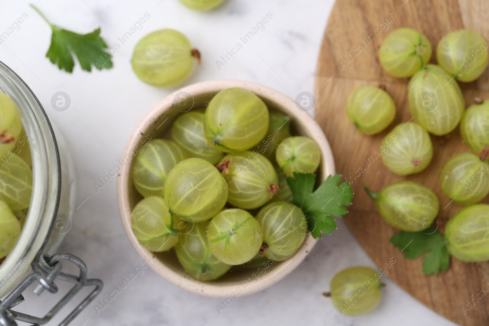 Fresh green gooseberries on white marble table, flat lay Photo of Fresh green gooseberries on white marble table, flat lay