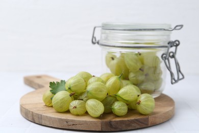 Photo of Fresh green gooseberries on white table, closeup