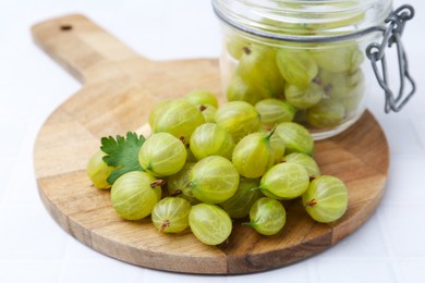 Photo of Fresh green gooseberries on white table, closeup