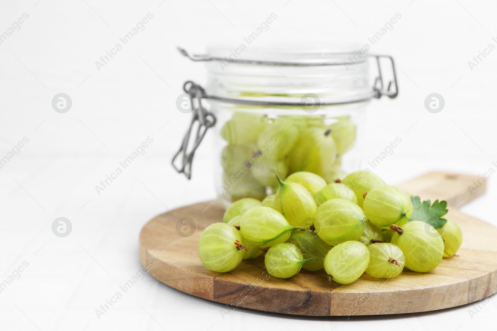 Fresh green gooseberries on white tiled table, closeup Photo of Fresh green gooseberries on white tiled table, closeup