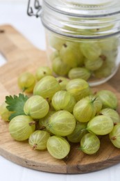 Photo of Fresh green gooseberries on white table, closeup