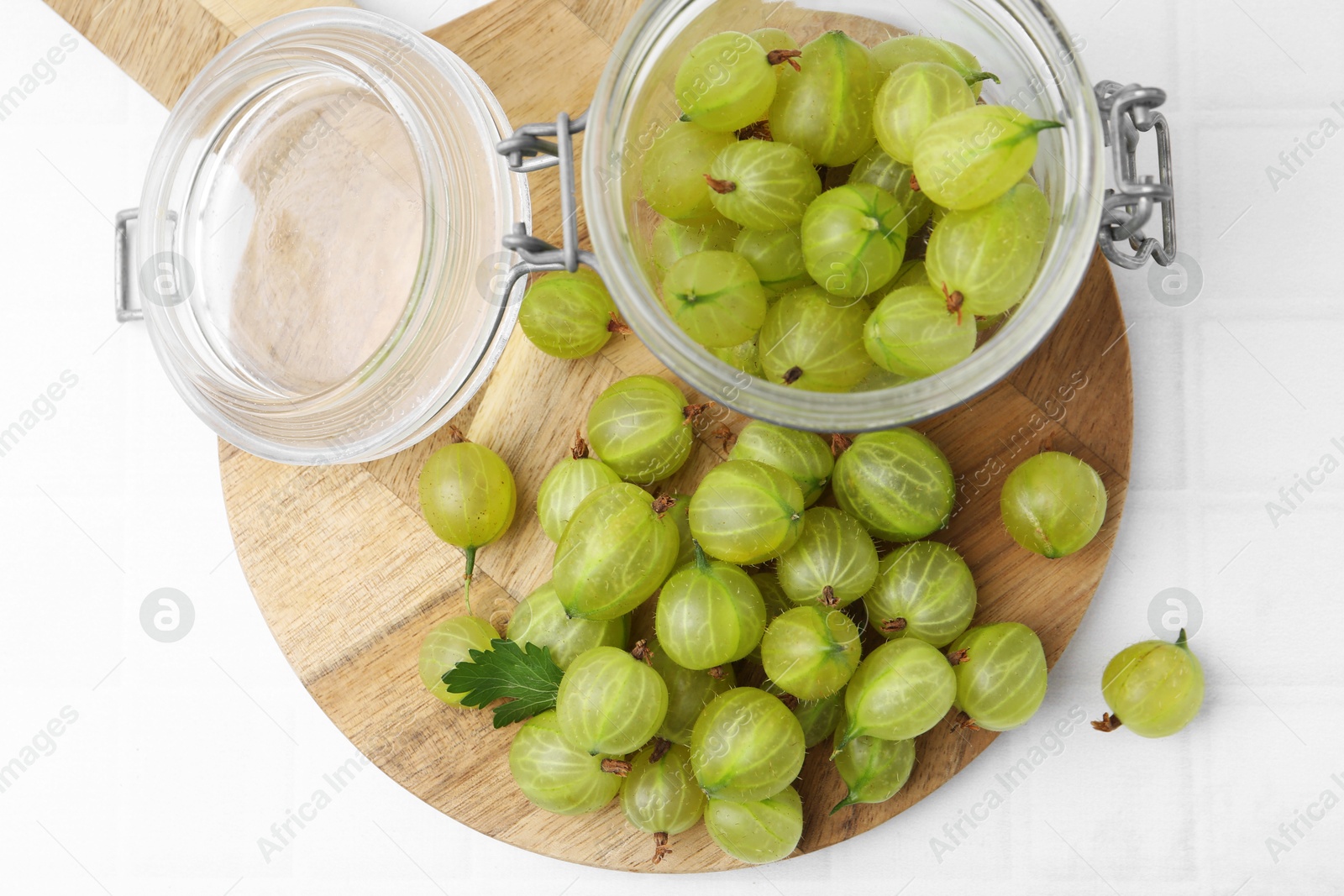 Fresh green gooseberries on white tiled table, top view Photo of Fresh green gooseberries on white tiled table, top view