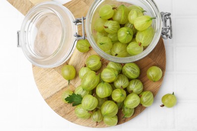 Photo of Fresh green gooseberries on white tiled table, top view