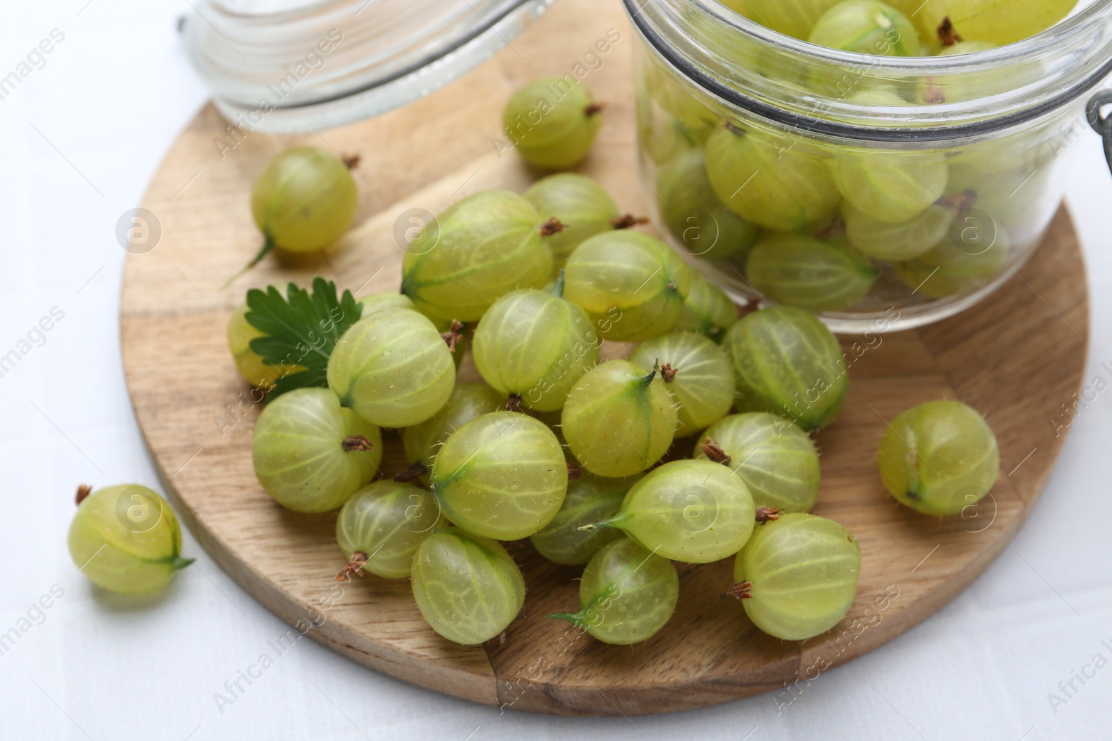 Fresh green gooseberries on white tiled table, closeup Photo of Fresh green gooseberries on white tiled table, closeup