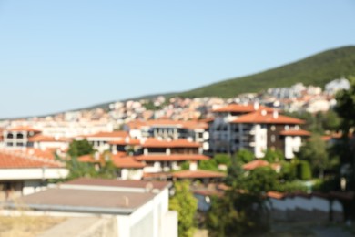 Photo of Blurred view of buildings and green mountain
