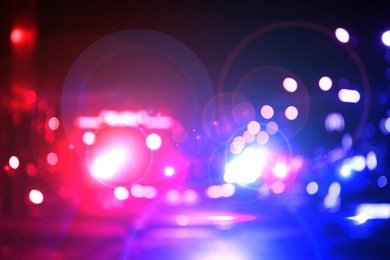 Image of Police red and blue lights in city at night, blurred view