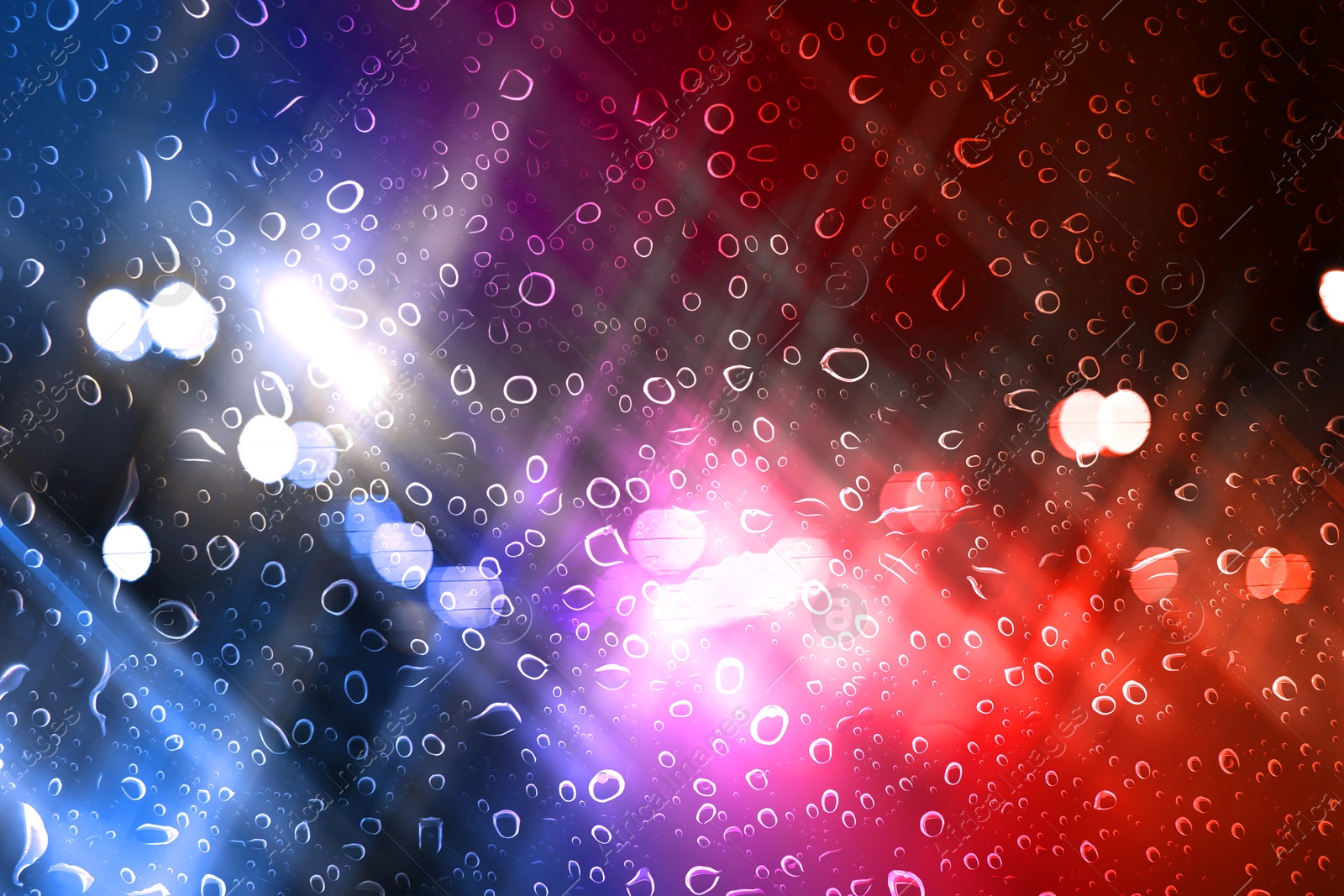 Image of Police red and blue lights in city at night, blurred view through wet glass