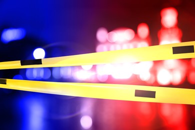 Image of Police red and blue lights and yellow Crime Scene Do Not Cross tape