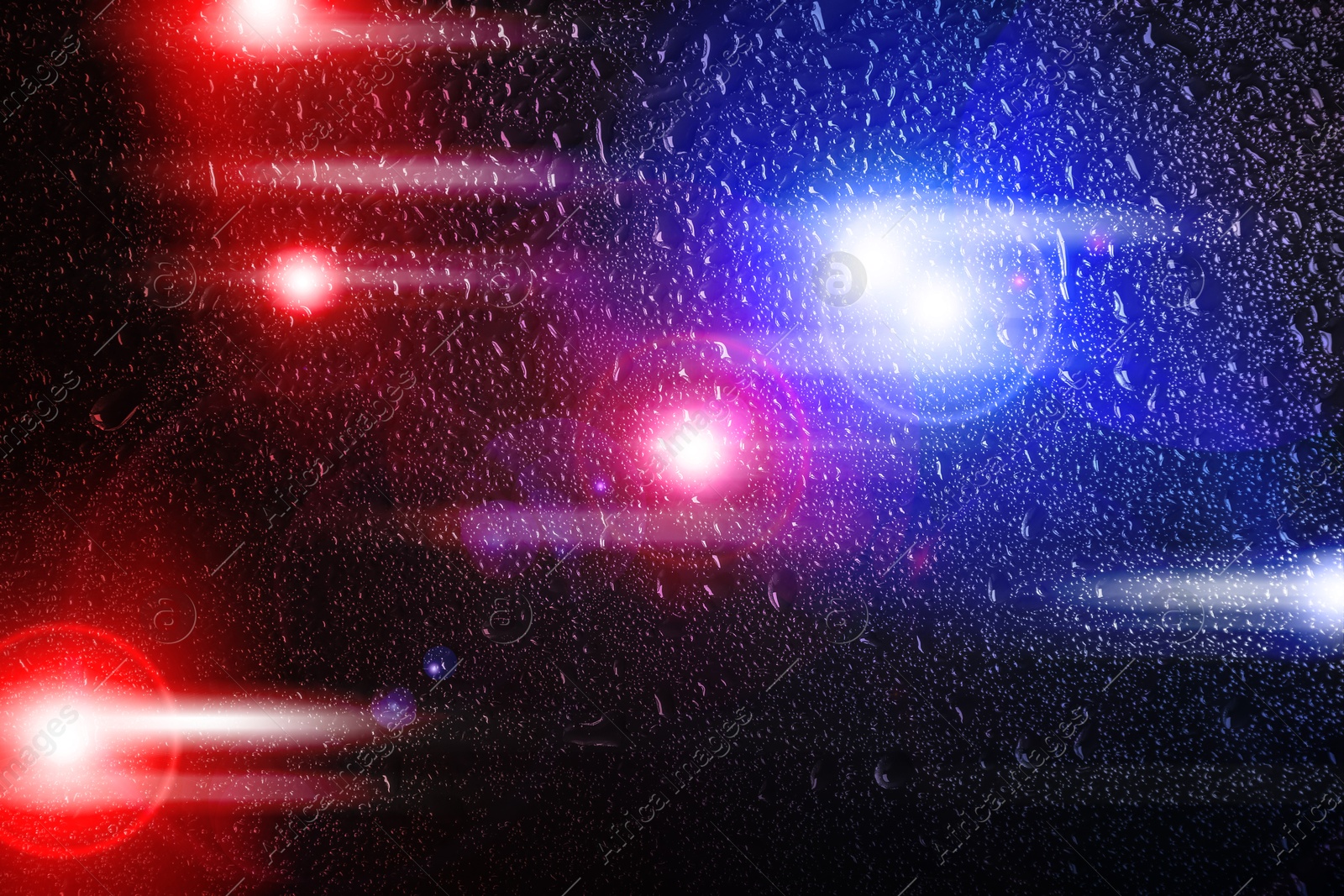 Image of Police red and blue lights, blurred view through wet glass
