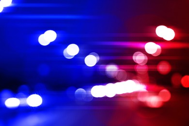Image of Police red and blue lights in city at night, blurred view