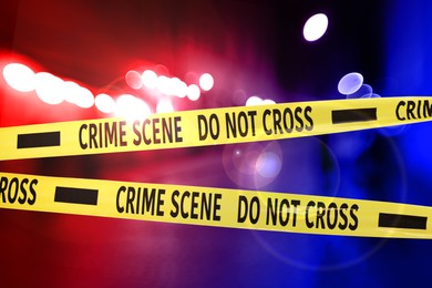 Image of Police red and blue lights and yellow Crime Scene Do Not Cross tape